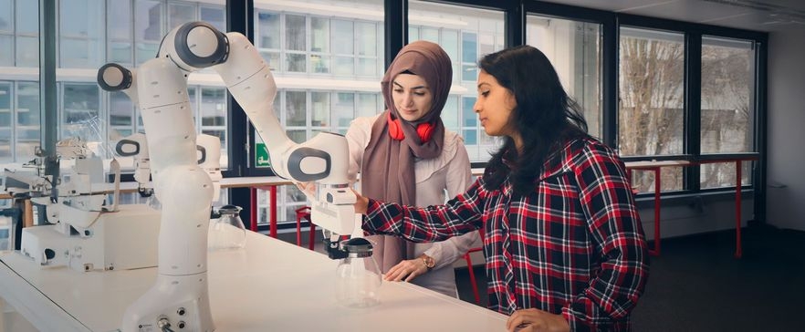 Zwei Frauen arbeiten an einem Roboter