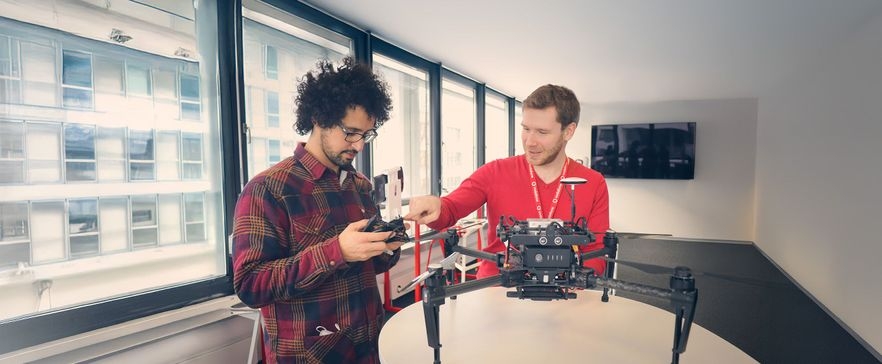 Zwei Männer mit einer Drohne im Büro