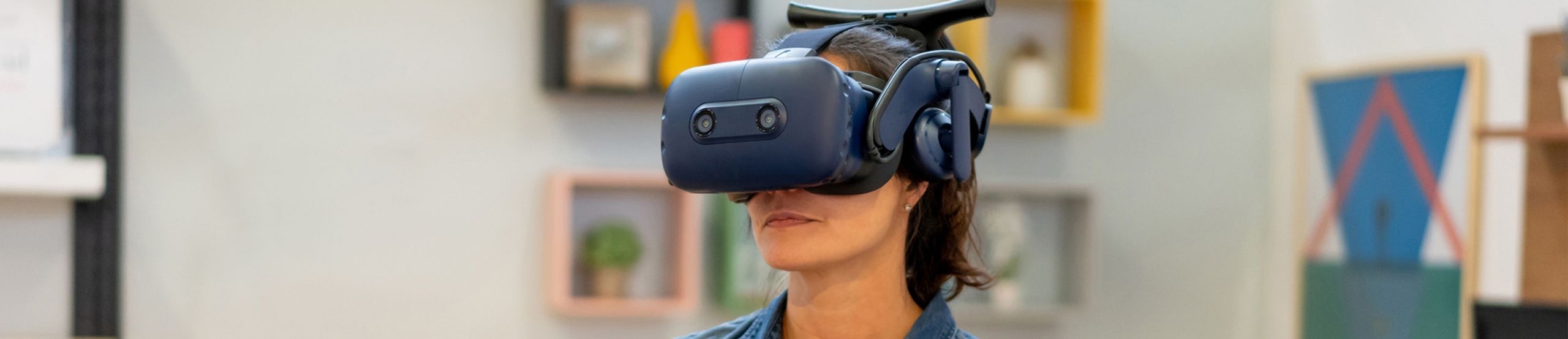 Eine Frau trägt eine VR-Brille und hält einen VR-Controller in der Hand