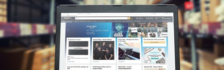 Ein Notebook mit der Amazon-Webseite auf dem Display steht auf einem Tisch