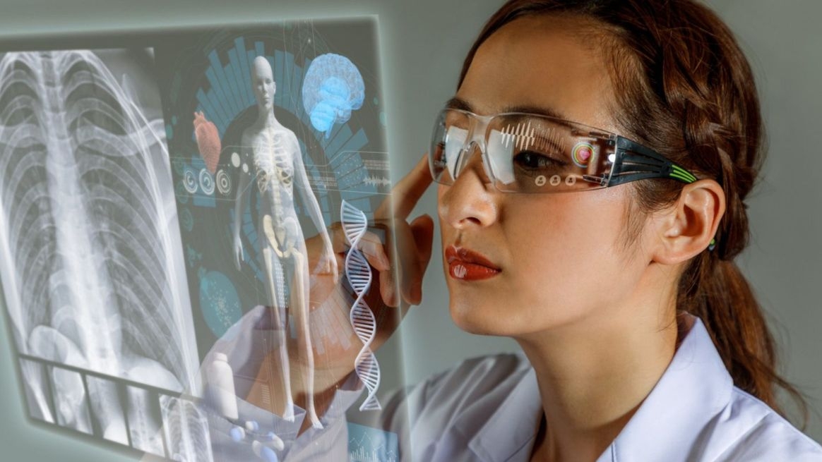 Frau mit weißem Kittel und smarter Brille schaut auf projiziertes Röntgenbild eines menschlichen Körpers