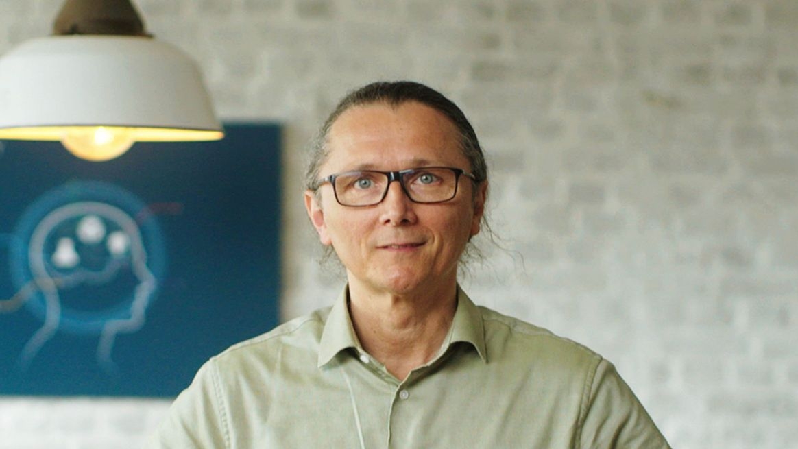 CUREosity-Gründer Thomas Saur vor einer Backsteinwand