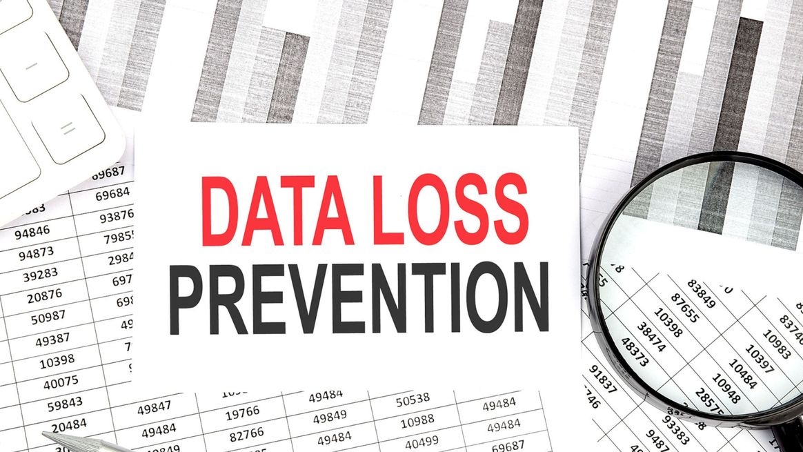 Zahlen unter der Lupe und ein Zettel mit der Aufschrift „Data-Loss-Prevention“