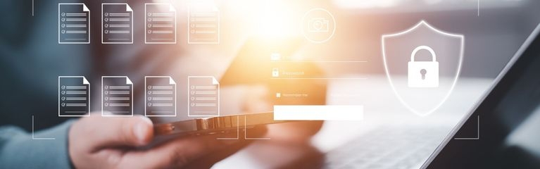 Hände, die ein Smartphone halten, über der Tastatur eines Notebooks, davor stilisierte Symbole für Textdateien und ein virtuelles Vorhängeschloss
