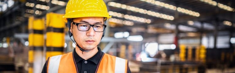 Ein Arbeiter mit einem Notebook in einer Fabrik