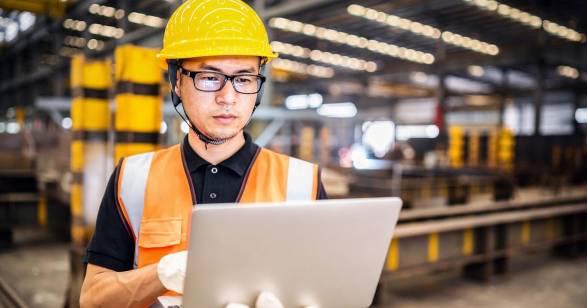 Ein Arbeiter mit einem Notebook in einer Fabrik