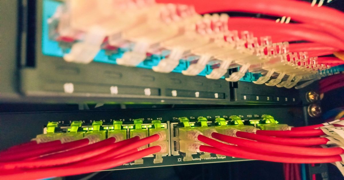 Switches eines Netzwerks, an die viele rote Netzwerkkabel angeschlossen sind.