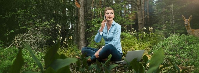 Eine Frau telefoniert im Wald