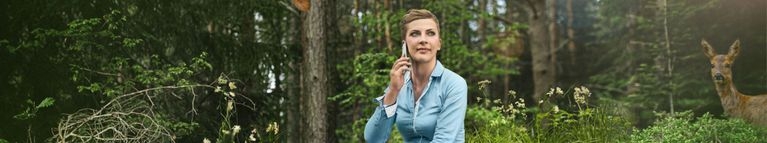 Eine Frau telefoniert im Wald