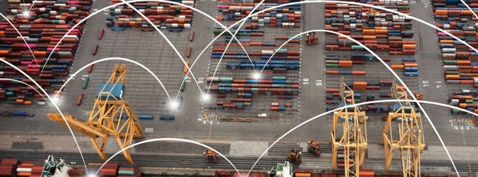 Das Foto zeigt einen Containerhafen, in dem stilisierte Lichbögen die Contaniner miteinander verbinden.