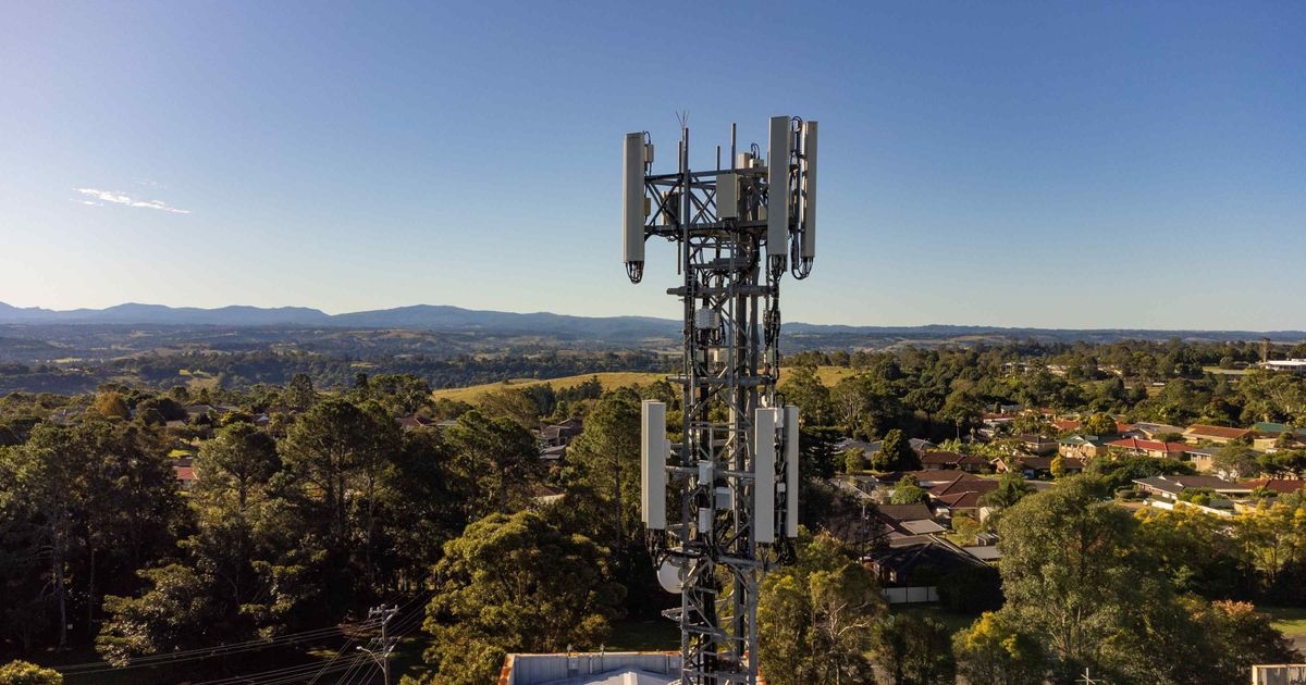 Telekommunikationsturm mit Mobilfunk-Antenne über Bäumen