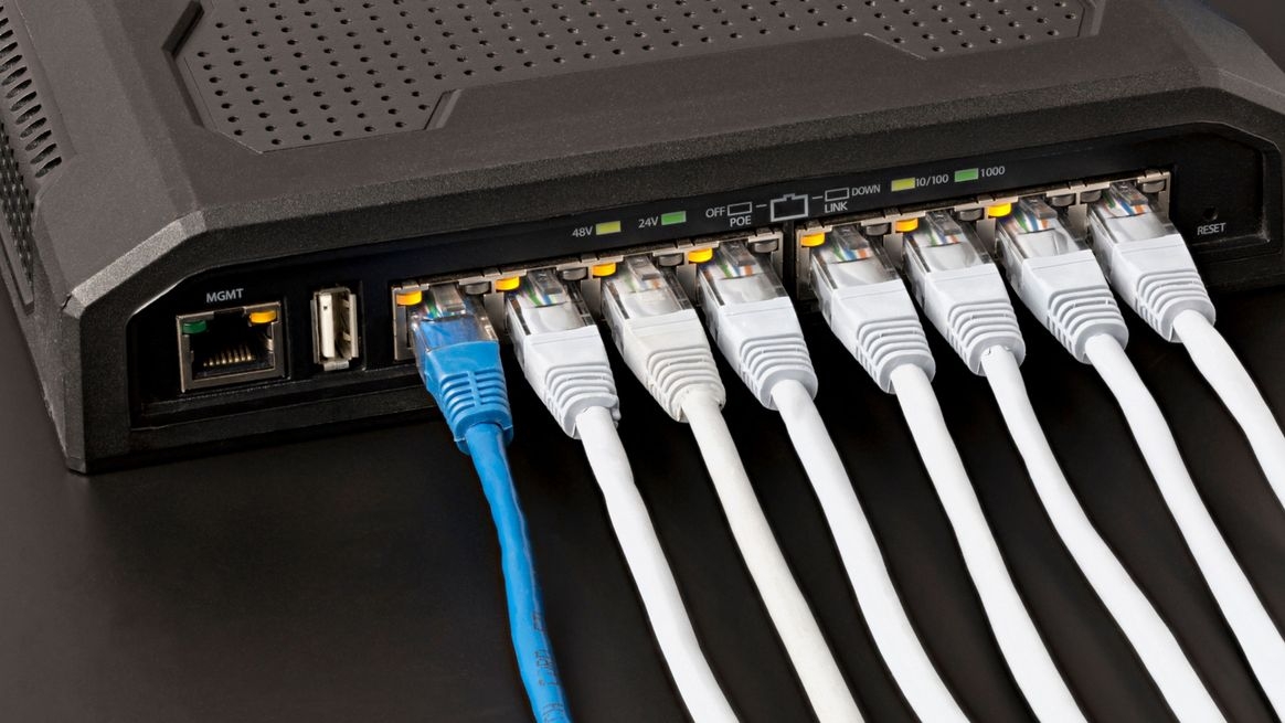 = Acht Ethernet-Stecker stecken in benachbarten Anschlüssen. Über den Anschlüssen Anzeigenleuchten für die PoE-Stromversorgung.