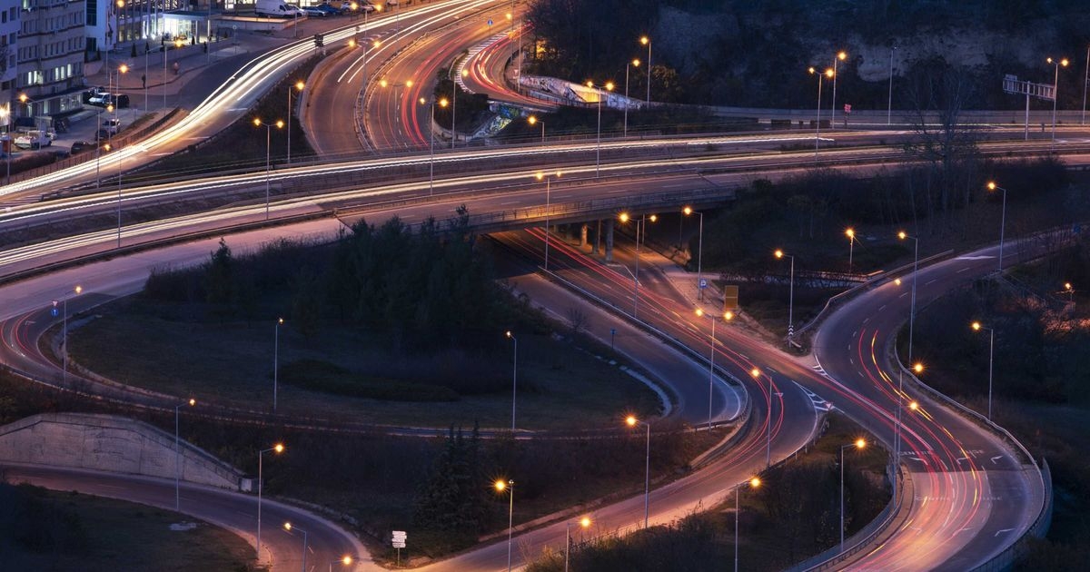 Eine Autobahnkreuzung in der Nacht mit Lichtstreifen auf den Fahrbahnen