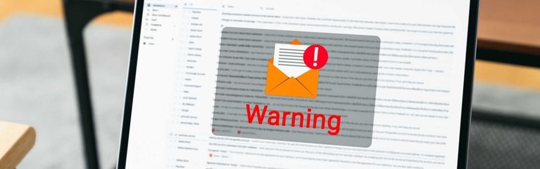 Der Bildschirm eines Notebooks mit der Ansicht eines E-Mail-Clients, davor das Symbol eines geöffneten Briefumschlags mit einem roten Ausrufezeichen und dem Schriftzug Warning