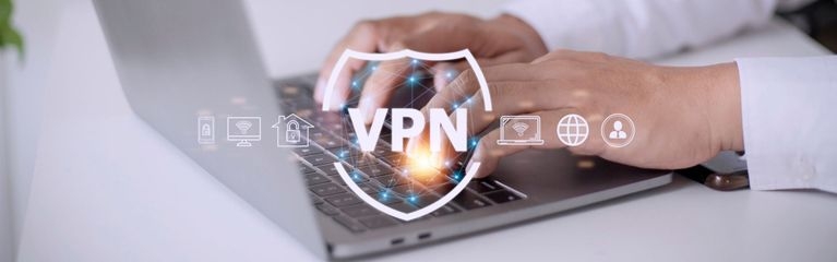 Eine Person tippt auf einem Notebook. Darüber im Vordergrund Computersymbole und die Abkürzung VPN