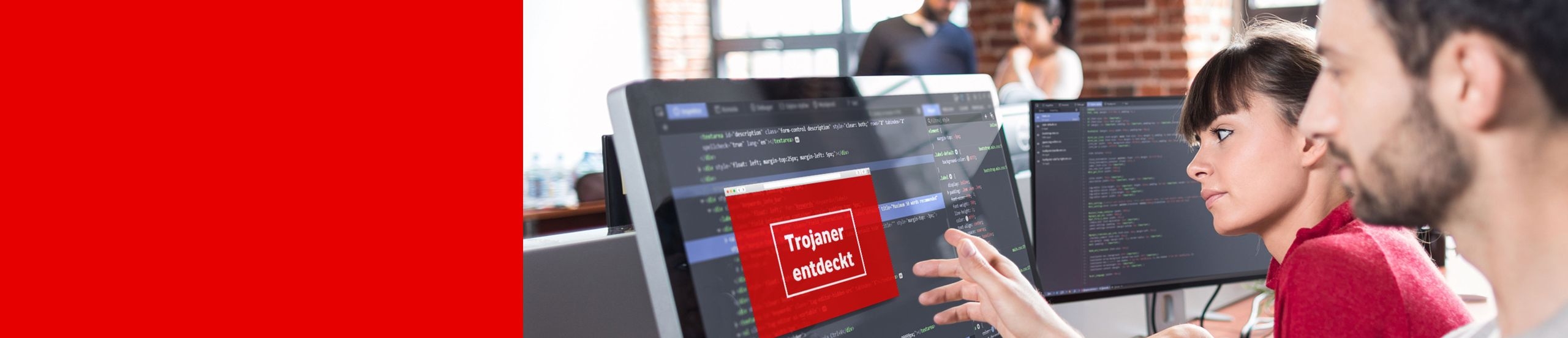 Ein Mann und eine Frau sitzen vor einem Computerbildschirm mit Programmcode. Auf dem Bildschirm der Warnhinweis „Trojaner entdeckt“.