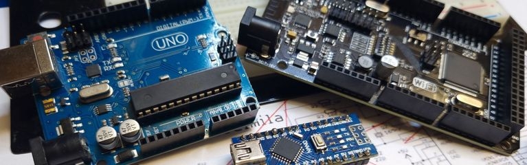 Drei verschieden große Arduino-Boards auf einem Schaltplan und einem Breadboard