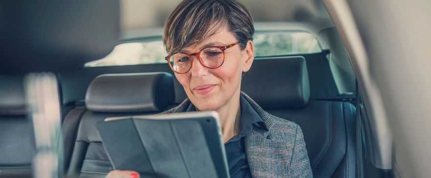 Frau im Auto mit Tablet