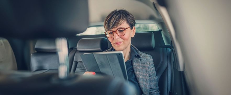 Frau im Auto mit Tablet