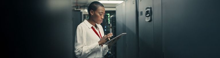 Frau mit Tablet im Serverraum