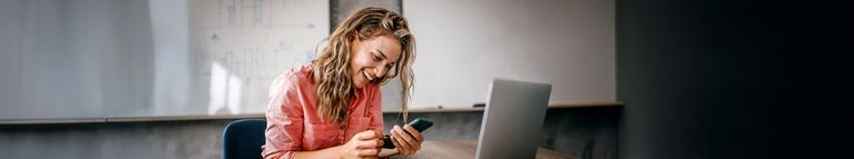 Frau mit Handy und Laptop