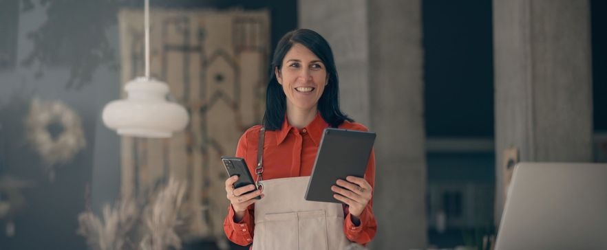 Frau, die Tablet und Smartphone in der Hand hält